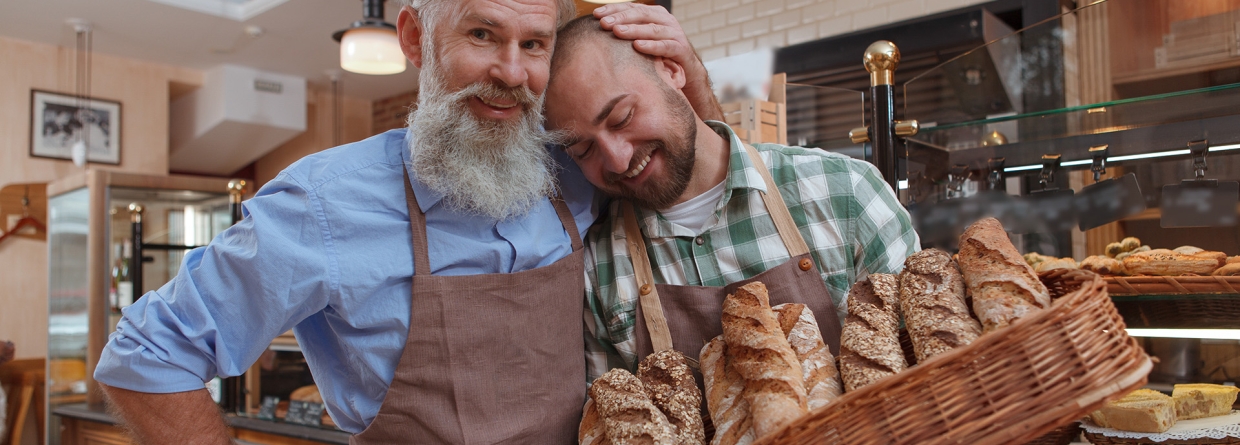 Vader knuffelt zoon in zijn bakkerij
